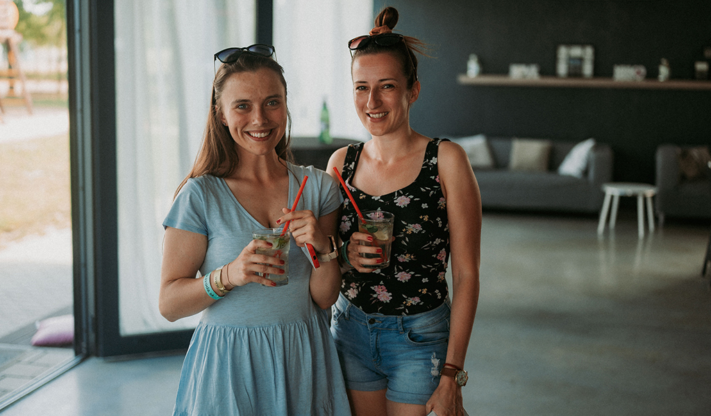 Two women posing with their drinks