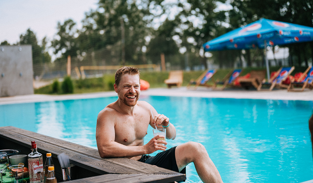 Man in a swimming pool with a drink