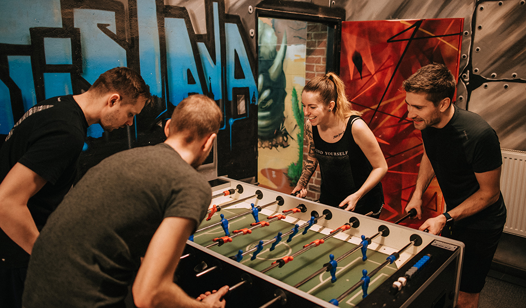 Four team members playing table football