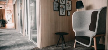 Silent space with armchair and side table and the office corridor