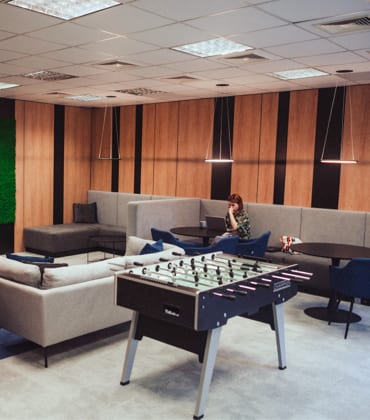 Lounge with table football and a colleague working on her laptop