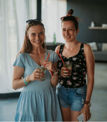 Two women posing with their drinks