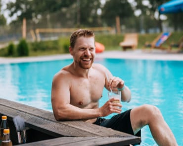 Man in a swimming pool with a drink