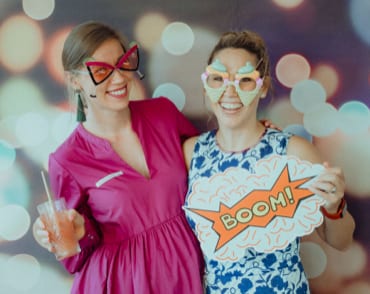 Two team members posing for a photo booth
