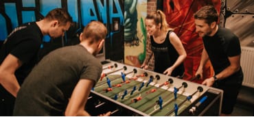Four team members playing table football