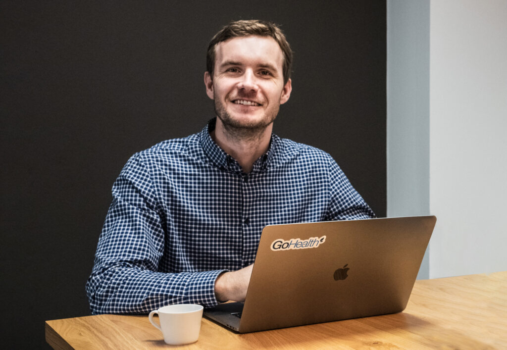 Developer smiling and working on his laptop.