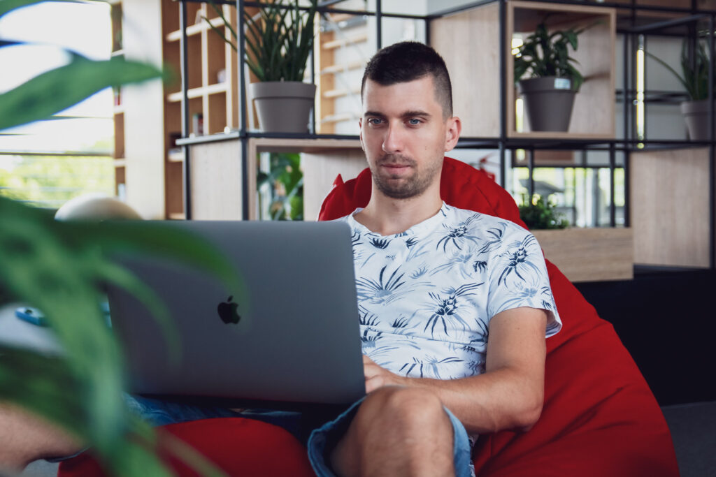 Software Engineer working in a bean bag.