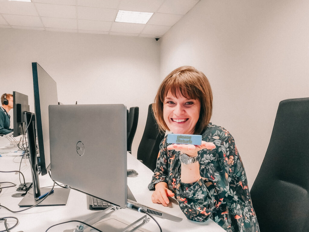 Female QA Tester smiling and holding an eraser with a motto.