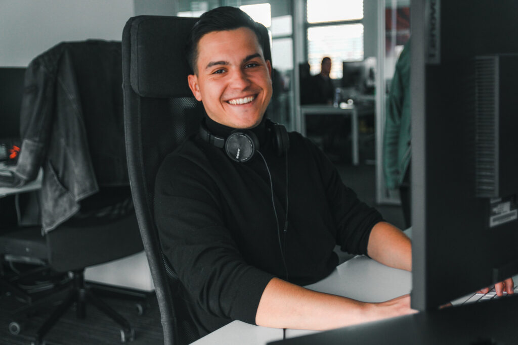 QA Tester smiling and working in the office.