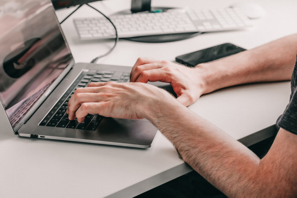 Detail of hands typing on computer.