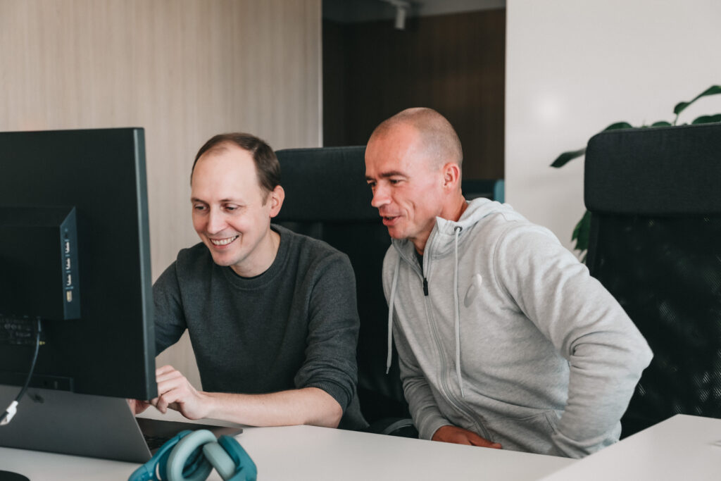 Two software engineers working on a computer.