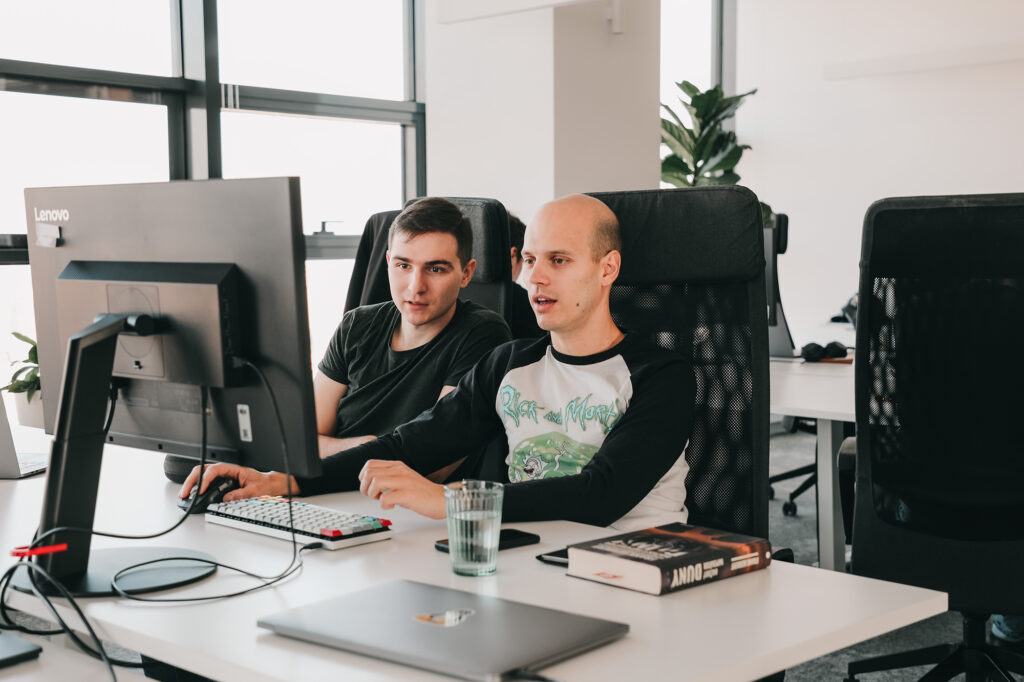 two software engineers collaborating on a computer