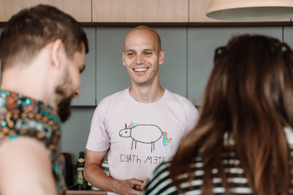 detail on a smiling man in a pink death metal t-shirt