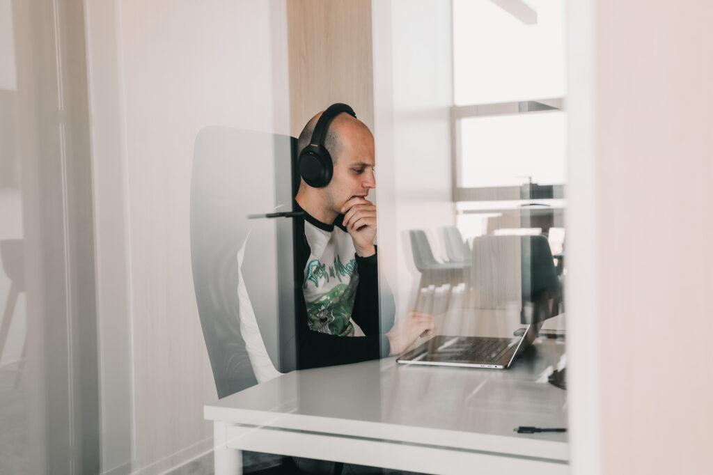 software engineer working on a laptop with headphones on