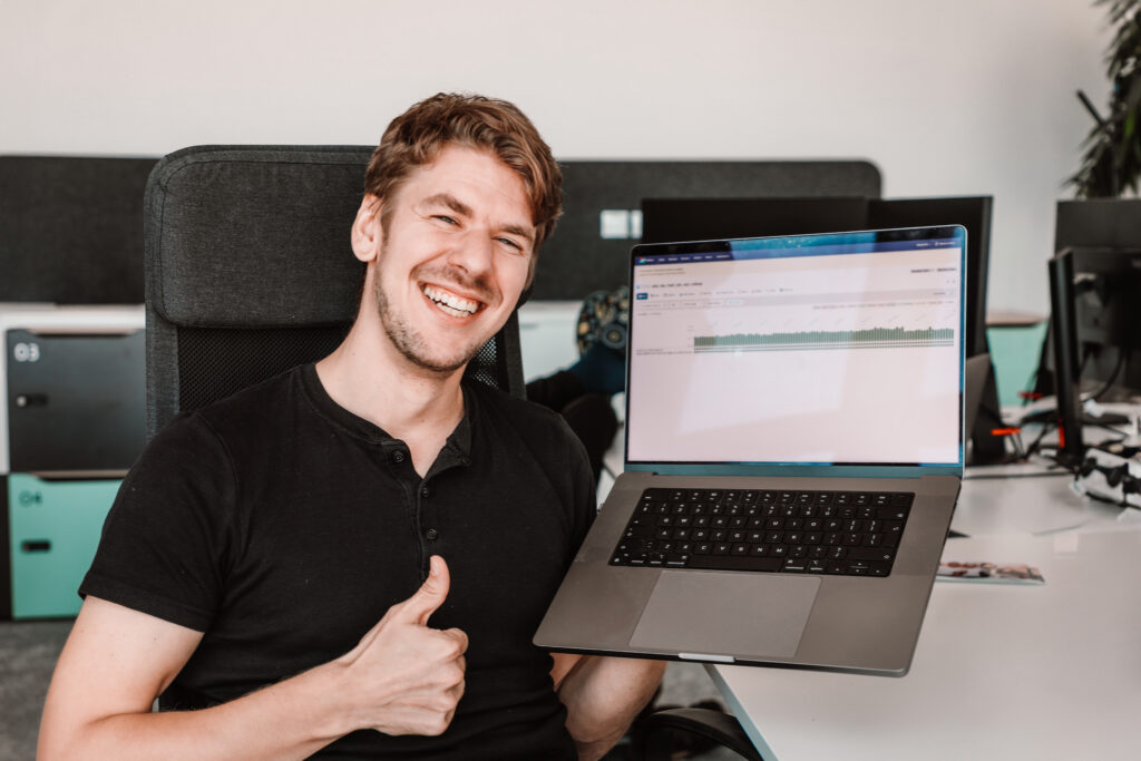 Male Data Engineer smiling with his laptop