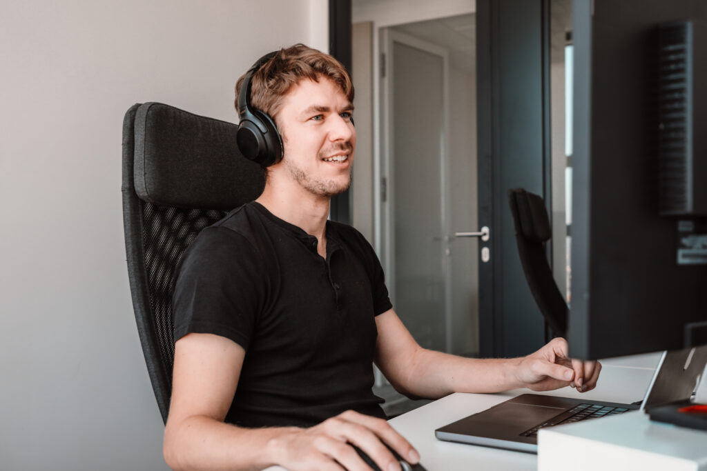 male data engineer working on his laptop with headphones on