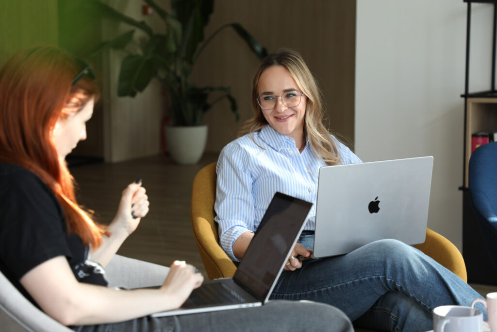 two females watlking with their laptops on their knees