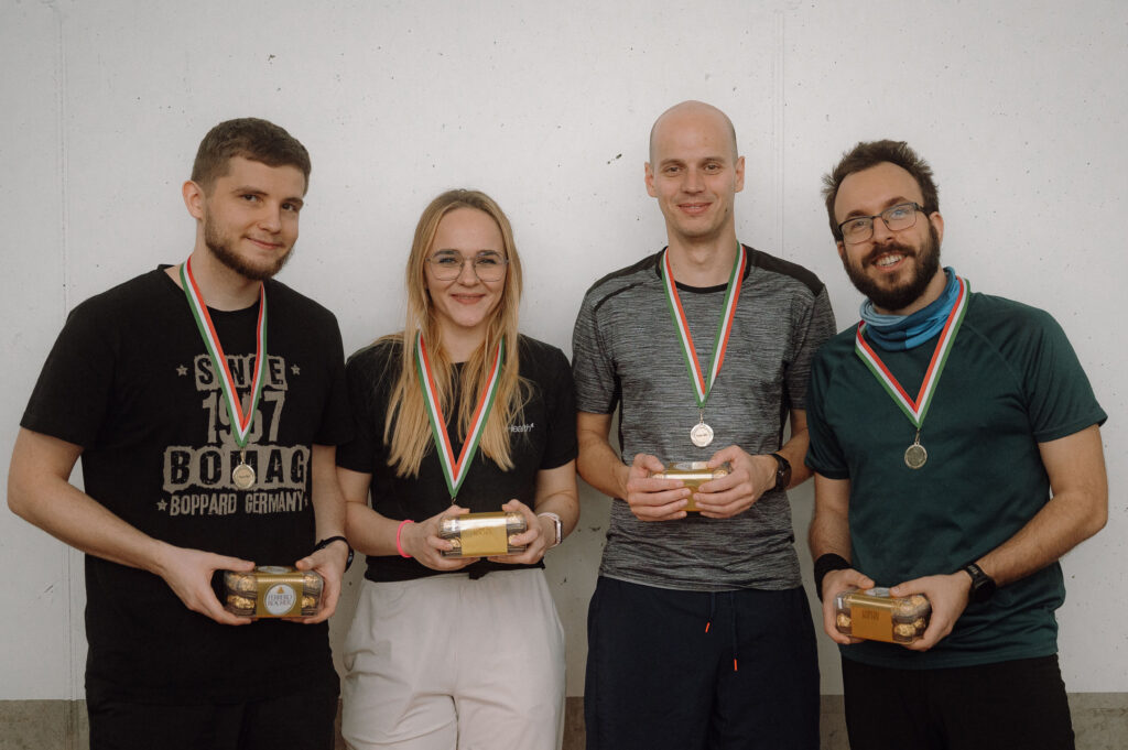 one female and three male colleagues posing with a trophies after a team building