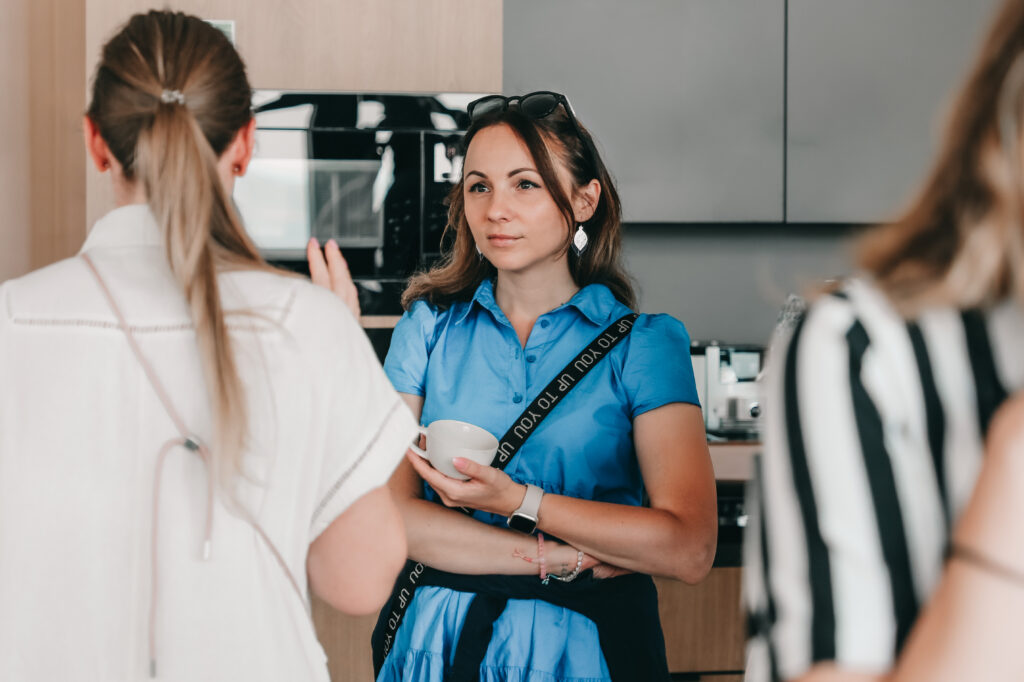 a female project manager mid-conversation with a cup of coffee in her hand