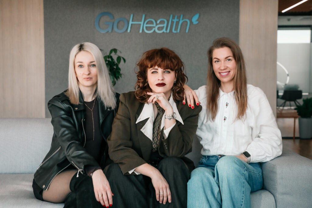 three female project managers posing for a picture on a couch